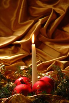 Candles and Christmas balls on a gold background