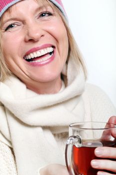 Mid age Woman With Hot tea Wearing Winter Clothes on a white background