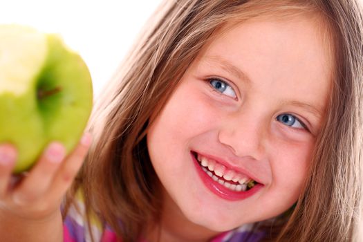 Portrait of little girl eating green apple