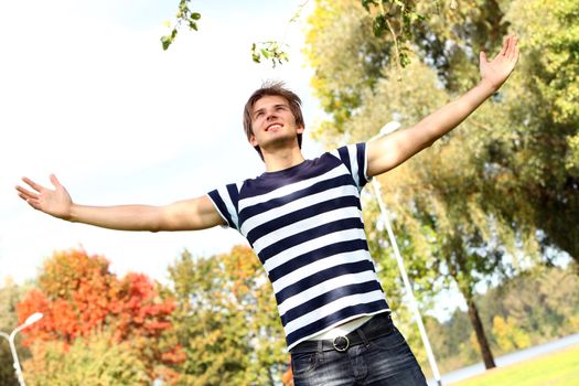 Portrait of happy and attractive young man at warm day in autumn park