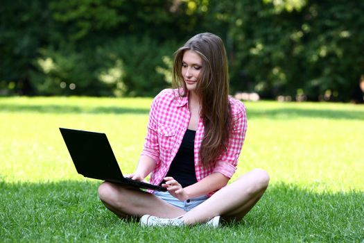 Young and beautiful woman with laptop in park
