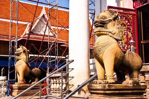 The lion statues made ​​of stone. Stand in front of a temple in Thailand at Phetchaburi province.