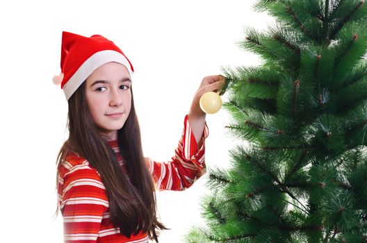 Young girl wearing beanie decorating christmas tree, eye contact, horizontal shot