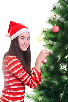 Young girl wearing beanie decorating christmas tree, eye contact, vertical shot