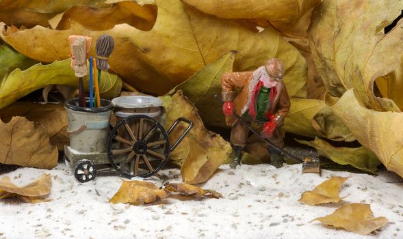 autumn athmosphere with man with broom wagon cleaning up