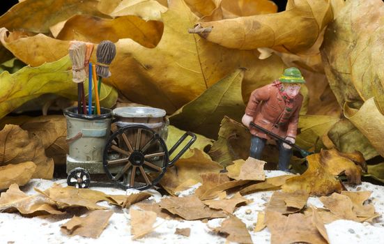 autumn athmosphere with man with broom wagon cleaning up