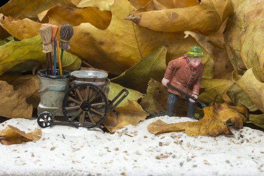 autumn athmosphere with man with broom wagon cleaning up