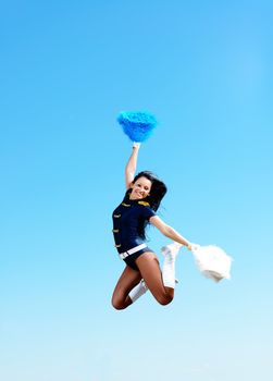 cheerleader girl jumping on a background of blue sky