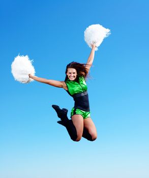 cheerleader girl jumping on a background of blue sky