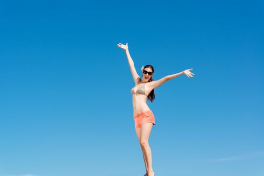 beautiful woman spread her arms against the blue sky, a good time