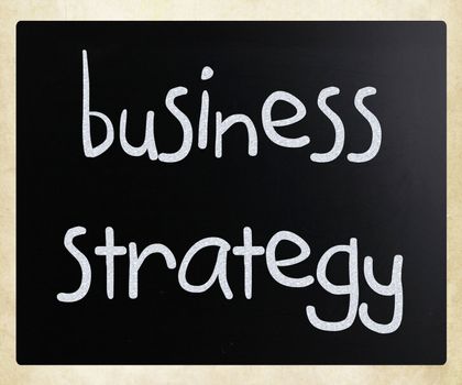 "Business strategy" handwritten with white chalk on a blackboard.