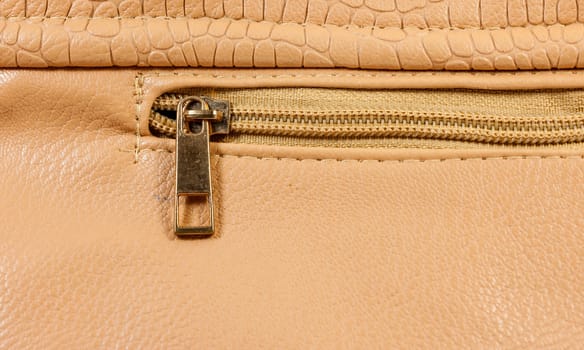 Closeup copper zipper of brown handbag leather