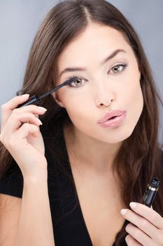 pretty woman applying mascara