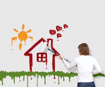 Young man with a paintbrush and family picture on the wall