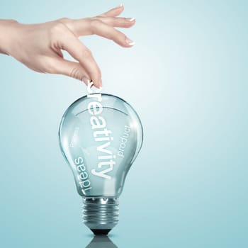 Human hand putting word Information inside a light bulb