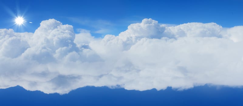 bright blue sky with sun shining and some clouds