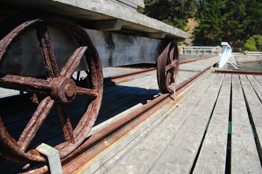 Metal wheels of old wagon on pier, Banks Peninsula, New Zealand