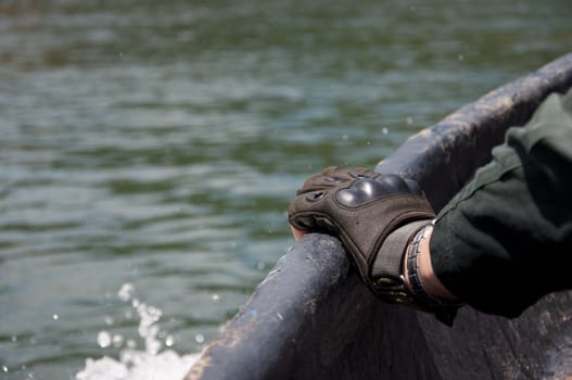 a man hand with a glove hold on running boat