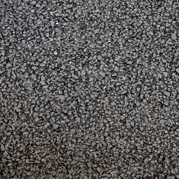 Closeup of the black tar surface of an asphalt road for textural background.