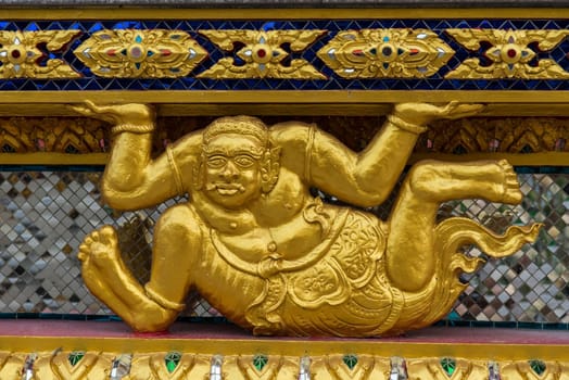 Asian golden demon statue in a sitting position