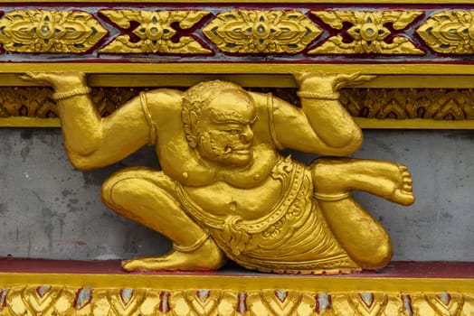 Asian golden demon statue in a sitting position