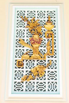 Ancient golden chinese temple sculpture on a window