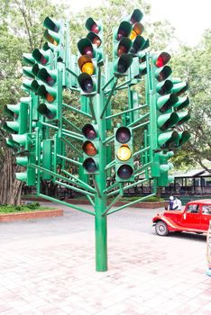 Multiple large traffic lights post made from green metal, taken on a cloudy day