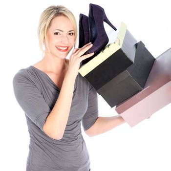 Smiling blonde woman holding high heels and shoe boxes on white background