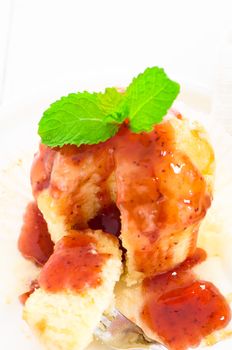 muffin with tasty strawberry sauce and fresh mint leaf on white plate