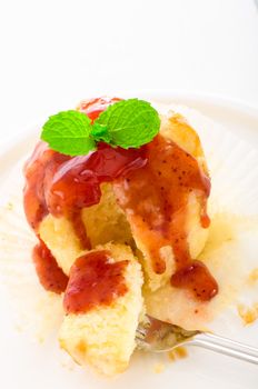 muffin with tasty strawberry sauce and fresh mint leaf on white plate