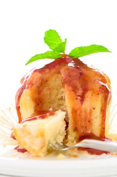 muffin with tasty strawberry sauce and fresh mint leaf on white plate