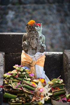 Typical outdoor Balinese Hindu statue with a lot of offerings 