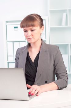 portrait of a beautiful young woman who works at a laptop in the office