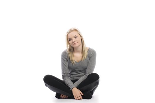 beautiful teenage girl sitting cross legged on white