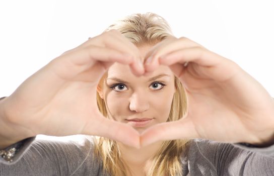 beautiful young woman framing her face with hands in heart shape