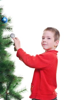 Young boy decorating christmas tree, looking at camera, vertical shot