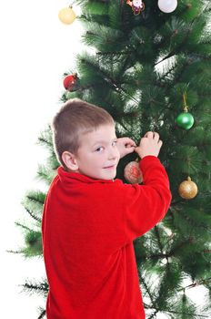 Young boy decorating christmas tree, looking at camera, vertical shot