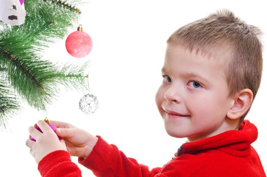 Young boy decorating christmas tree, looking at camera, horizontal shot