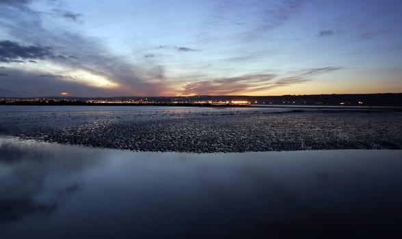 Night shot in the South of England with the moon reflecting on the still sea