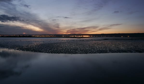 Twinkling lights and clouds reflecting on water