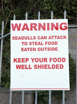Seagul warning sign attached to a railing