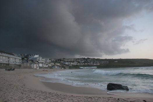 On the beach at St Ives as a storm comes over the bay