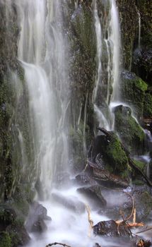 Water flowing down through rocks with moss 