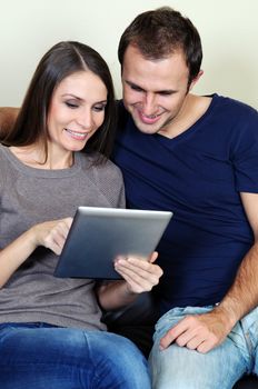 Couple using a tablet computer in their living room 