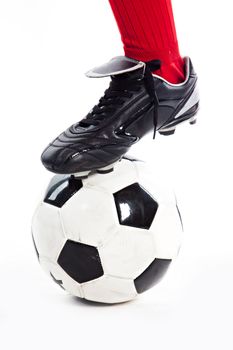 Foot in the red socks, and black shoes standing on a football