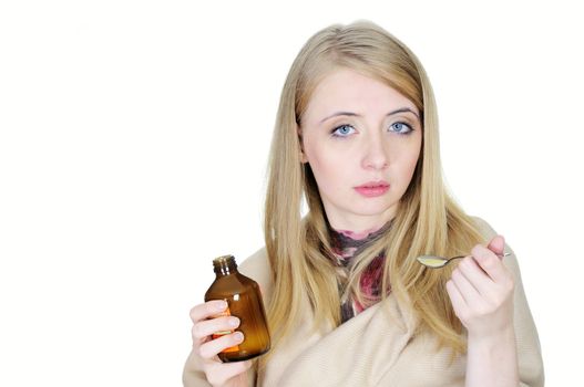 Young sick woman taking syrup