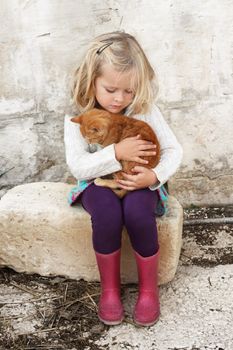 A young child hugging a small kitten, very tender moment, lots of love