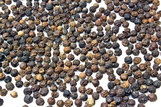 Close-up of peppercorns on white background.