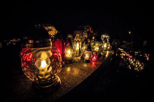 All Saints' Day at a cemetery in Poland - flowers and light candles to honor the memory of deceased relatives.