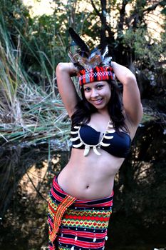 Native american woman posing next to a creek.